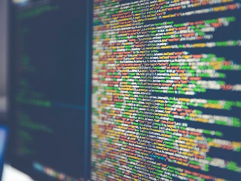 Bildschirm mit farbig hervorgehobenem Programmcode, leicht unscharf aus schrägem Winkel