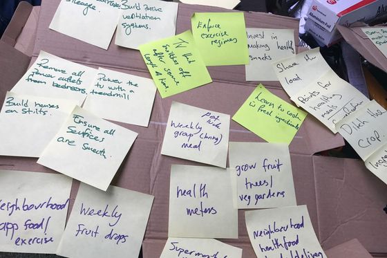 Handschriftliche Ideen auf gelben und grünen Haftnotizen, ausgelegt auf einem Karton