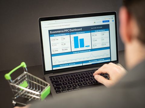 Laptop mit Analyse-Dashboard zu Kampagnen und Umsätzen, daneben ein Mini-Einkaufswagen